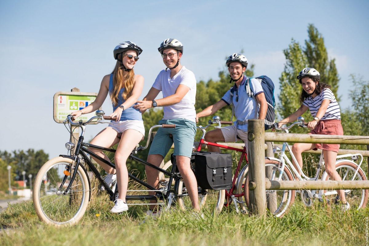 Deux couples de jeunes gens, en tandem et à vélo, sur la piste cyclable Vendée Vélo, portion de la Vélodyssée à Saint-Michel-en-l'Herm